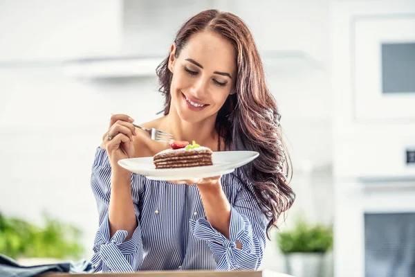 一个女人拿着一把叉子 上面夹着草莓和薄荷叶 上面铺着褐色和白色的蛋糕 — 图库照片