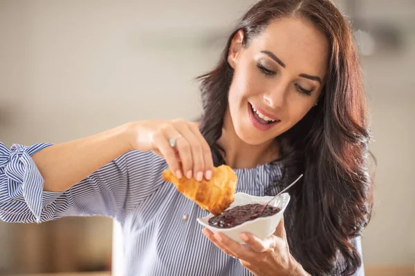 Mujer Sonríe Mientras Disfruta Del Desayuno Con Croissant Mermelada —  Fotos de Stock