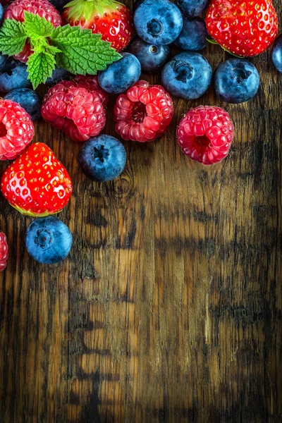 Fruits à baies sur fond ou table en bois. Bleuets, framboises, fraises, fruits de la forêt . — Photo