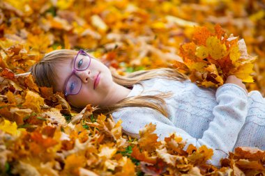 Genç kız üzerinde renkli akçaağaç yalan bir buket aynı yapraklarından holding eller bırakır