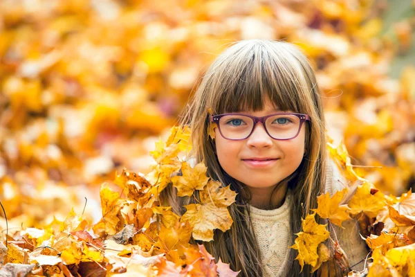 Portrait of a young pretty girl who was cheerfully playing with autumn maple leaves. — Stock Photo, Image