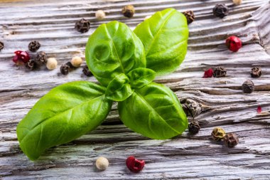 Eski ahşap bir masa üzerinde biber ve makarna fesleğen yaprağı