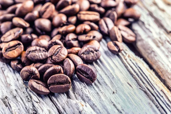 Grains de café sur fond en bois grunge. — Photo