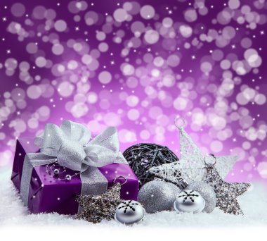 Noel paketi, Hediyelik gümüş Şerit'in mor. Jingle Bells, Noel topları ve kar üzerinde koymak Noel yıldız gümüş. Çok renkli bulanık arka plan boşluk.