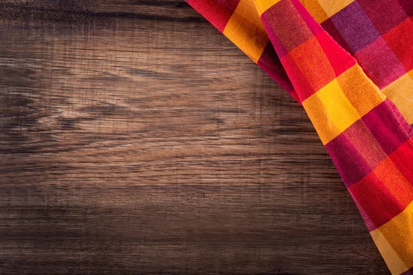 Vue du dessus de la serviette à carreaux sur une table en bois — Photo