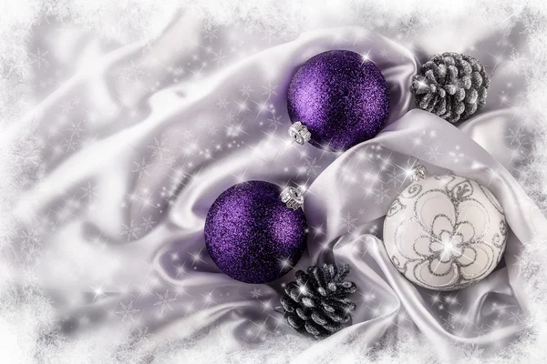 Luxury Christmas balls Silver pine cones on white satin Christmas decoration combined purple and silver colors. Glittering background of bright stars and snowflakes. Frozen Frame — Stock Photo, Image