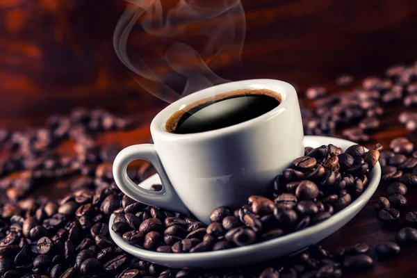 Kopp kaffe och utspillt kaffe bönor. — Stockfoto