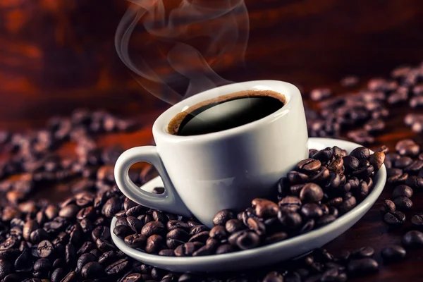 Xícara de café e grãos de café derramados . Fotografias De Stock Royalty-Free