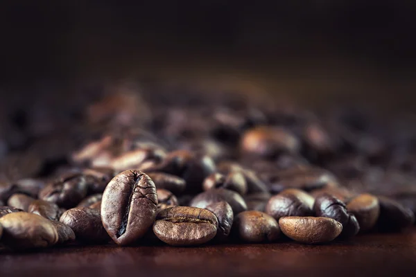 Grains de café torréfiés sur la table. — Photo