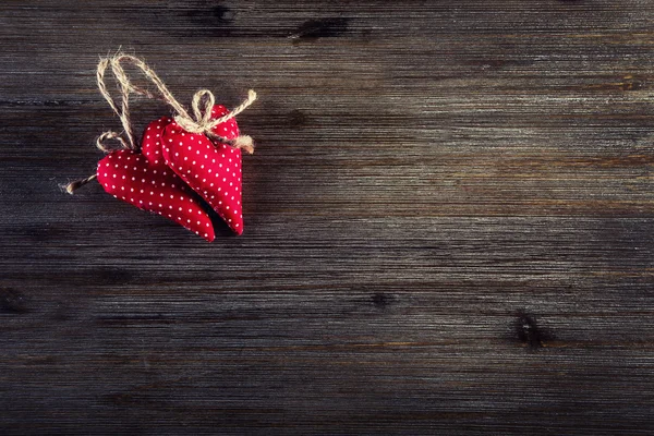 Día de San Valentín. Corazones hechos a mano de tela roja sobre fondo de madera — Foto de Stock