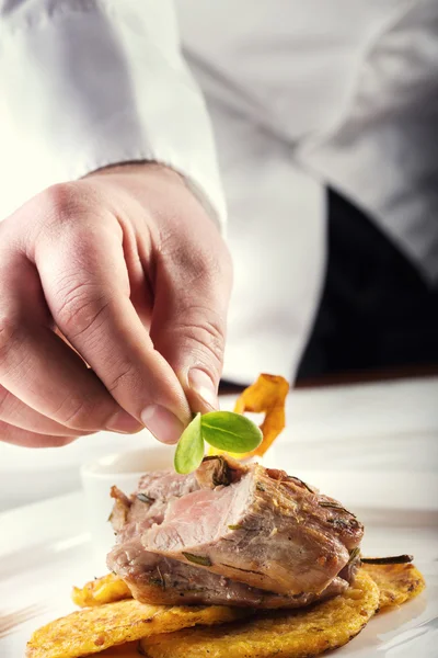 Chef em cozinha de hotel ou restaurante, apenas mãos. Bife de carne preparado com panquecas de batata ou aipo . — Fotografia de Stock