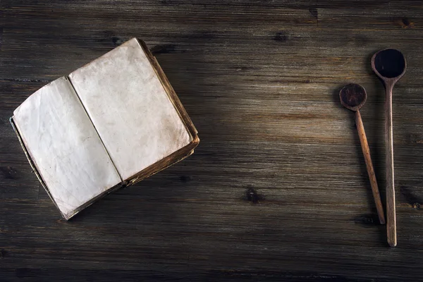 Gamla öppna bok utan text gamla trä sked på ett träbord — Stockfoto