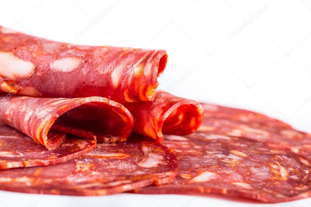 Cut Spanish sausage or salami chorizo. Isolated on white