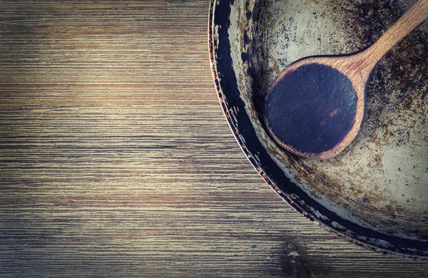 Utensilios de cocina de madera sobre la mesa. Libro de recetas cuchara de madera vieja sartén en un estilo retro en la mesa de madera — Foto de Stock