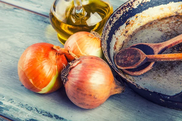 Gamla köket panorera träsked tre lök Karaff med olivolja på träbord. — Stockfoto