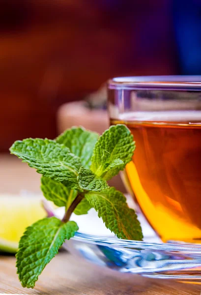 Tea in a glass bottle, mint leaves, dried tea, sliced lime, cane sugar — Stock Photo, Image