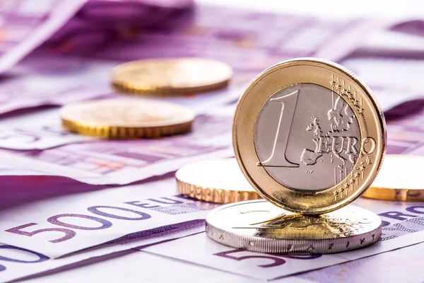 Several 500 euro banknotes and coins are adjacent. Symbolic photo for wealth. Euro coin balancing on stack with background of banknotes. — Stock Photo, Image