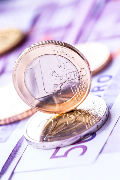 Several 500 euro banknotes and coins are adjacent. Symbolic photo for wealth. Euro coin balancing on stack with background of banknotes. — Stock Photo, Image