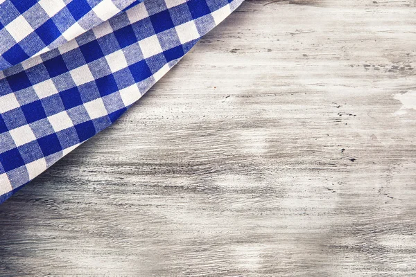 Top view of checkered napkin on wooden table. — Stock Photo, Image