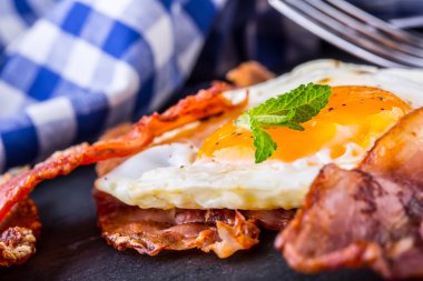 Jambon ve yumurta. Pastırma ve yumurta. Tuzlu yumurta ve kara biber ve yeşil ot dekorasyon ile serpilir.