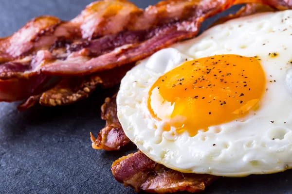 Presunto e Ovo. Bacon e Egg. Ovo salgado e polvilhado com pimenta preta . — Fotografia de Stock