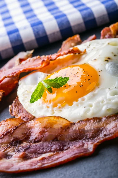 Presunto e Ovo. Bacon e Egg. Ovo salgado e polvilhado com pimenta preta e decoração de ervas verdes . — Fotografia de Stock