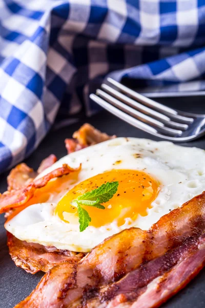 Presunto e Ovo. Bacon e Egg. Ovo salgado e polvilhado com pimenta preta e decoração de ervas verdes . — Fotografia de Stock