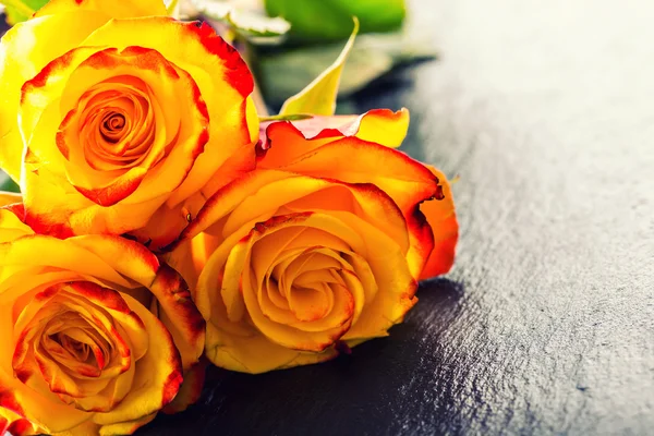 Πορτοκαλής αυξήθηκε. Κίτρινο τριαντάφυλλο. Αρκετές πορτοκαλί τριαντάφυλλα σε φόντο γρανίτη — Φωτογραφία Αρχείου