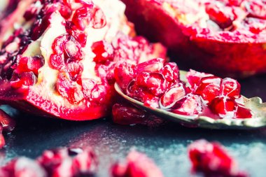 Parçalar ve olgun nar taneleri. Nar taneleri. Granit yönetim kurulu ve antika kaşık nar meyve parçası.