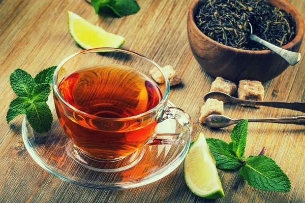 Thé dans une tasse en verre, feuilles de menthe, thé séché, lime tranchée — Photo