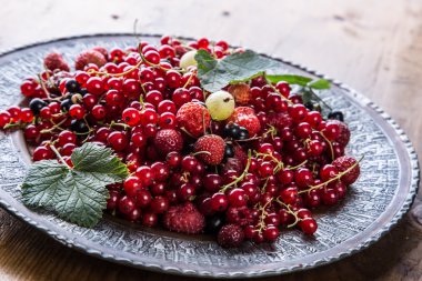 Red currant sponge cake. Plate with Assorted summer berries, raspberries, strawberries, cherries, currants, gooseberries.