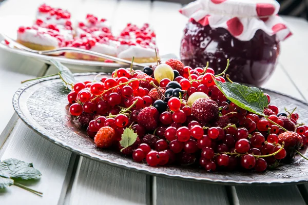 Red currant sponge cake. Plate with Assorted summer berries, raspberries, strawberries, cherries, currants, gooseberries.