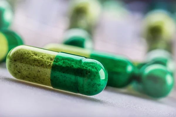 Pillen. Tabletten. Kapsel. Haufen Pillen. medizinischer Hintergrund. Nahaufnahme eines Haufens gelb-grüner Tabletten. — Stockfoto