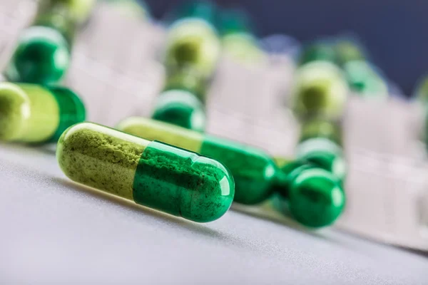 Pills. Tablets. Capsule. Heap of pills. Medical background. Close-up of pile of yellow green  tablets. — Stock fotografie