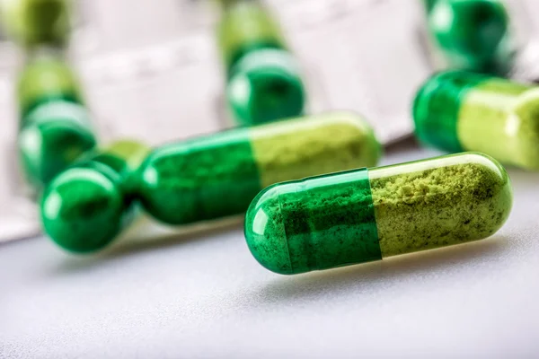 Pills. Tablets. Capsule. Heap of pills. Medical background. Close-up of pile of yellow green  tablets. — Stock Photo, Image