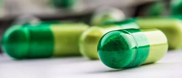 Pills. Tablets. Capsule. Heap of pills. Medical background. Close-up of pile of yellow green  tablets.