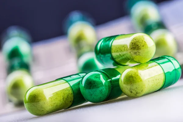 Pills. Tablets. Capsule. Heap of pills. Medical background. Close-up of pile of yellow green  tablets. — Stockfoto