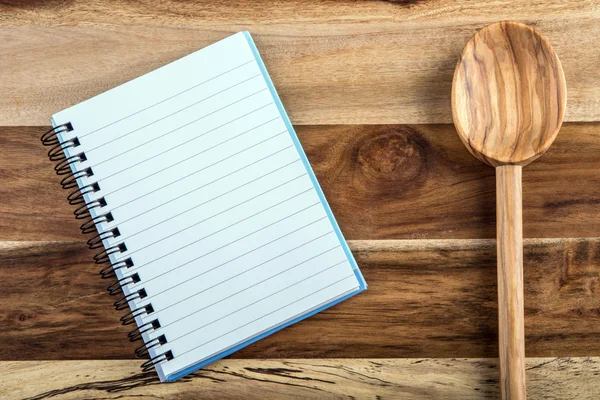 Libro de recetas abierto - cuaderno y cuchara de madera sobre fondo de madera —  Fotos de Stock