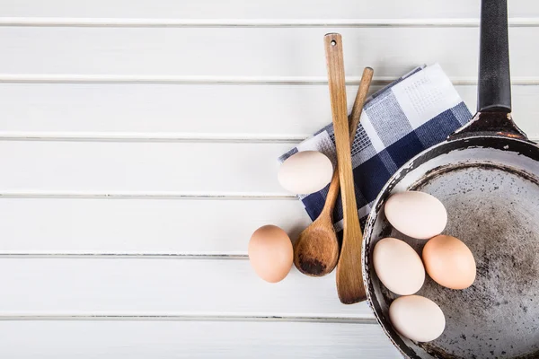 Wooden kitchen utensils on the table. Wooden spoon old pan in a retro style on wooden table. — Stockfoto