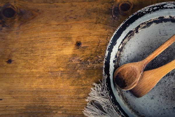 Wooden kitchen utensils on the table. Wooden spoon old pan in a retro style on wooden table. — Stockfoto