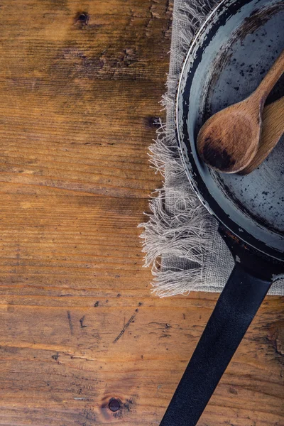 Wooden kitchen utensils on the table. Wooden spoon old pan in a retro style on wooden table. — Stockfoto