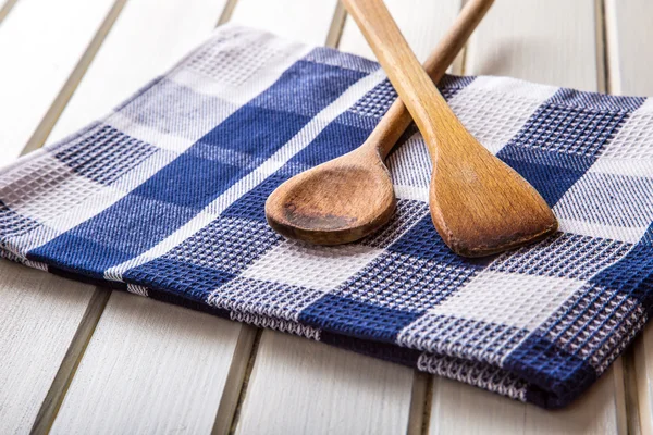 Two wooden cooking spoons on towel on wooden table. — Stock fotografie