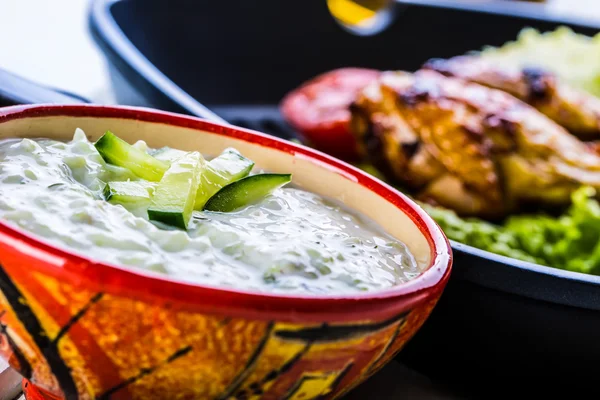 Tzatziki sauce. Tzatziki dressing. Tzatziki dressing with grilled chicken legs and fresh vegetable,lettuce leaf and cherry tomatoes. Grilled chicken legs, lettuce and tomatoes. — Stock Photo, Image