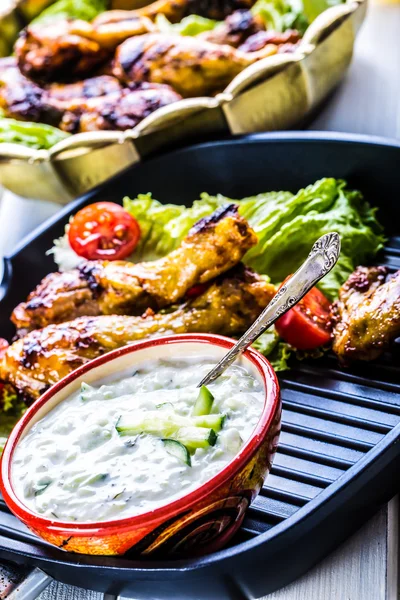 Tzatziki sauce. Tzatziki dressing. Tzatziki dressing with grilled chicken legs and fresh vegetable,lettuce leaf and cherry tomatoes. Grilled chicken legs, lettuce and tomatoes. — Zdjęcie stockowe