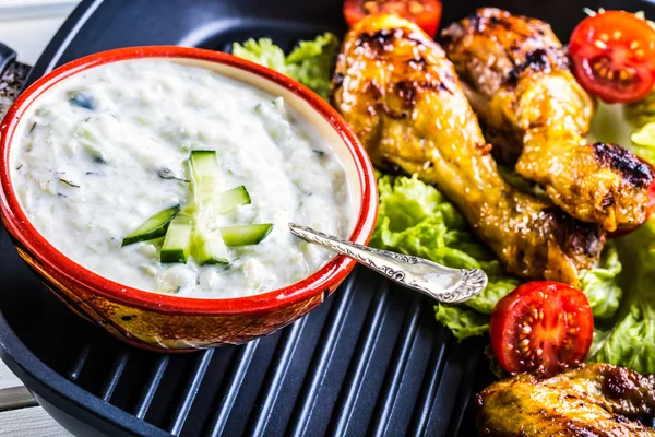 Tzatziki sauce. Tzatziki dressing. Tzatziki dressing with grilled chicken legs and fresh vegetable,lettuce leaf and cherry tomatoes. Grilled chicken legs, lettuce and tomatoes. — Stock Photo, Image