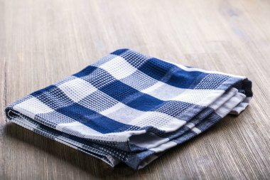 Damalı tuval bezi gevşek ahşap bir masaya koydu.