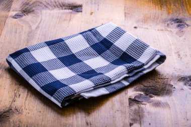 Damalı tuval bezi gevşek ahşap bir masaya koydu.