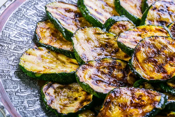 Zucchini. Grillad zucchini. Skivor av grillad zucchini på en tallrik. — Stockfoto