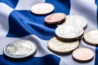 Greece and european  flag and euro money.  Coins and banknotes European currency freely laid on the European flag