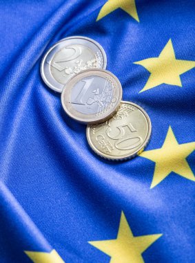 Greece and european  flag and euro money.  Coins and banknotes European currency freely laid on the European flag